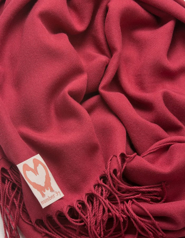 an image showing a close up of a pashmina in Mulberry red