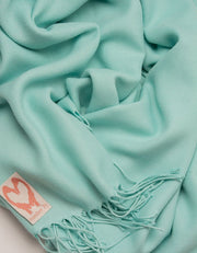 an image showing a close up of a pashmina in Turquoise