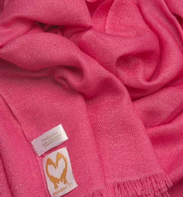 An image showing a cashmere wedding pashmina in hot pink close up