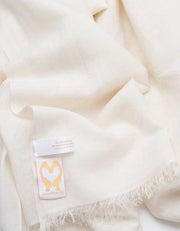 A close up image of a wool silk mix pashmina in ivory