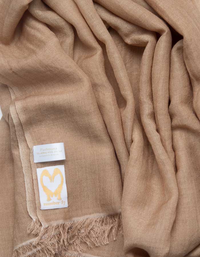 A close up image of a wool silk mix pashmina in light brown