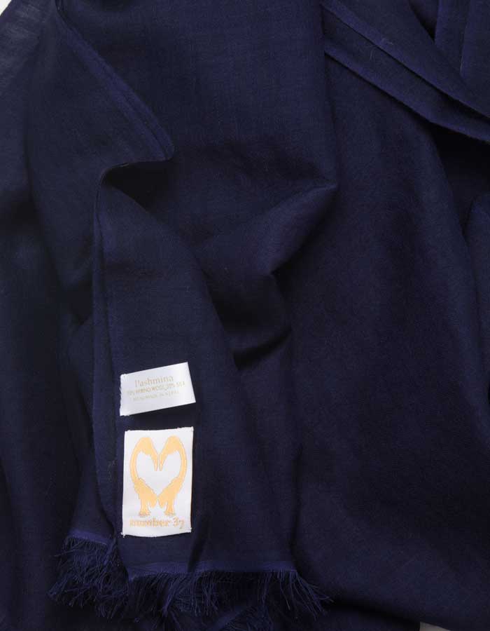 A close up image of a wool silk mix pashmina in navy blue