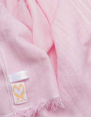 A close up image of a wool silk mix pashmina in pale pink