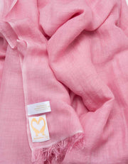 A close up image of a wool silk mix pashmina in pink