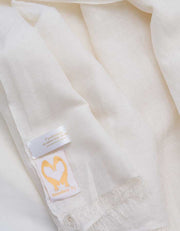 A close up image of a wool silk mix pashmina in white